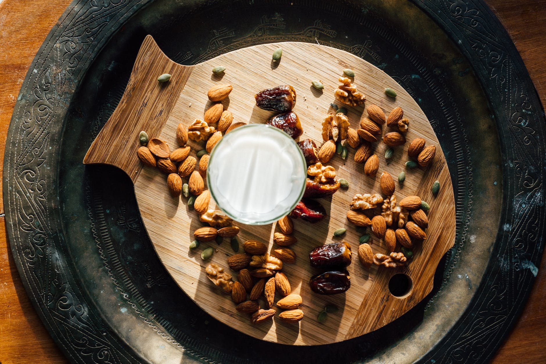 Glass of milk beside dates and nuts-do almond milk make you gain weight