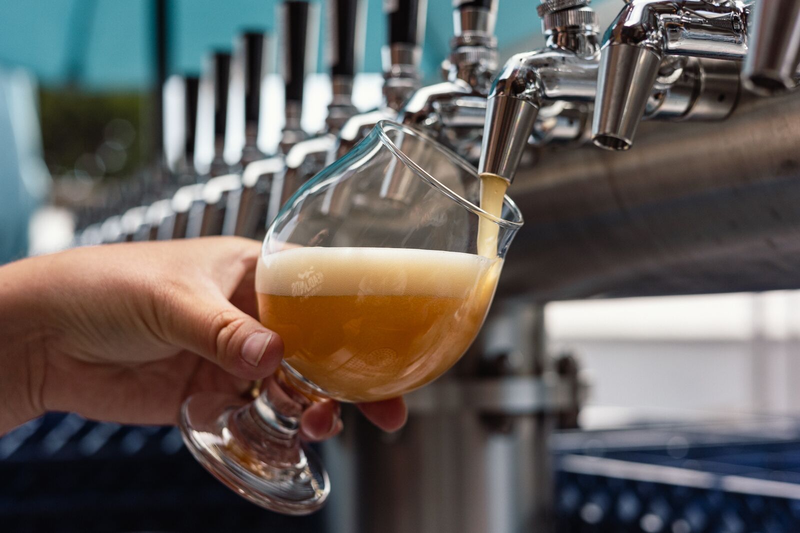 A beer is being poured from a tap into a glass.