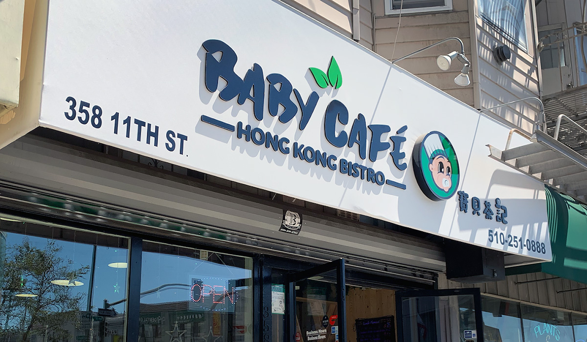 A white awning with "Baby Cafe Hong Kong Bistro" on it above a restaurant entrance.