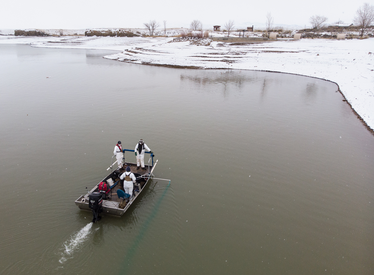 Three people sit in a boat filled with fear while snow covers the banks