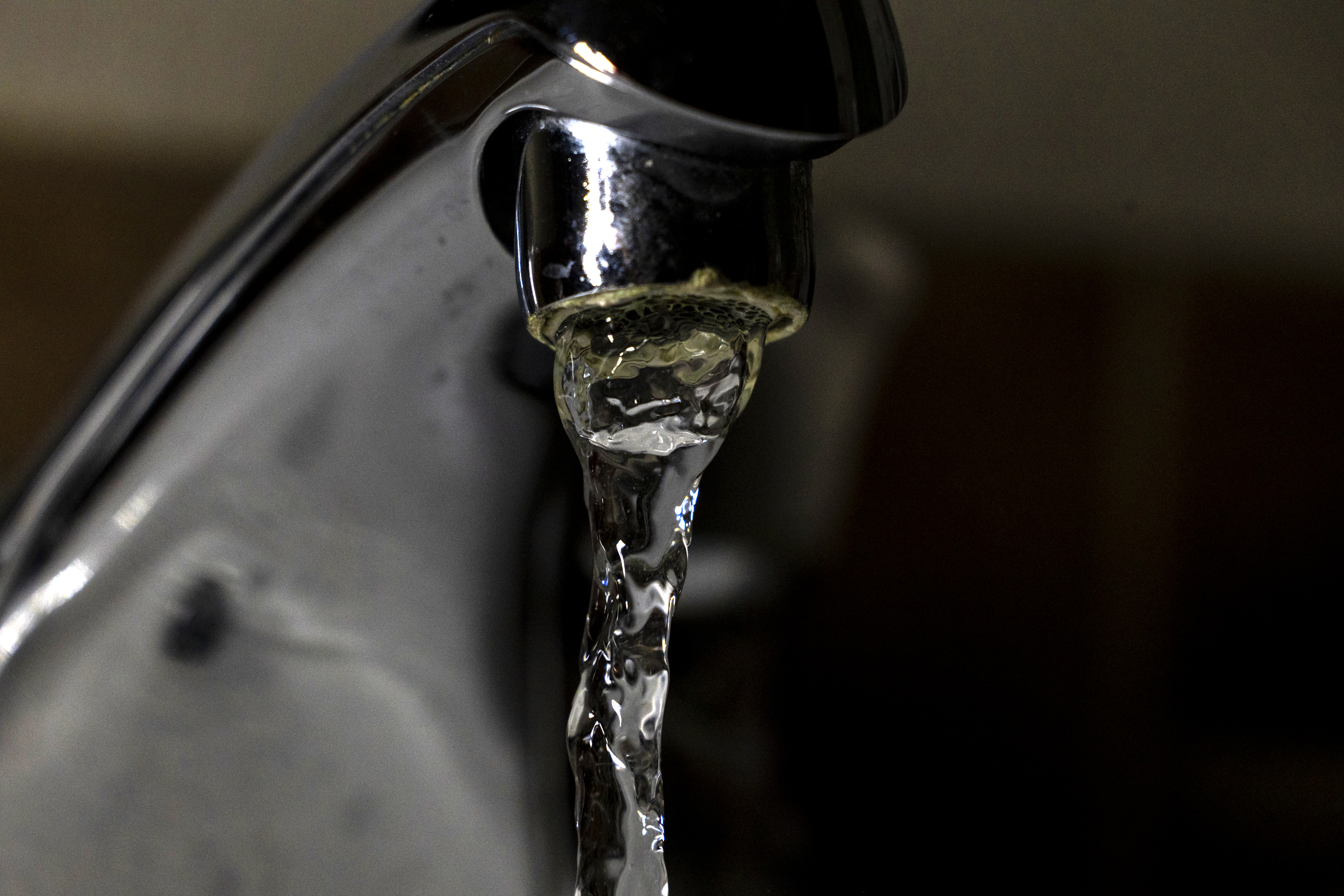 Water flows out of a sink faucet