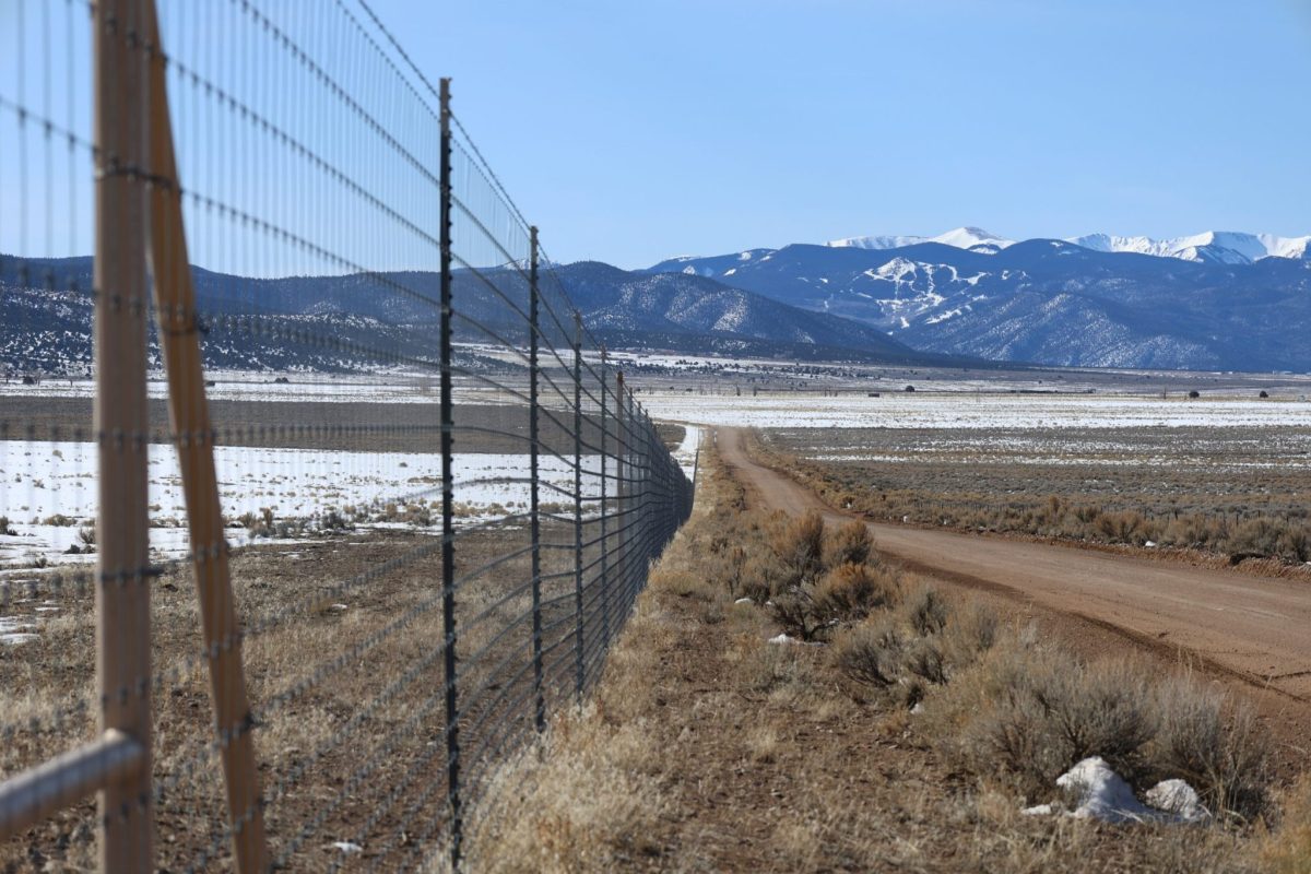 A tall fence separating Cielo Vista Ranch from the rest of the San Luis Valley