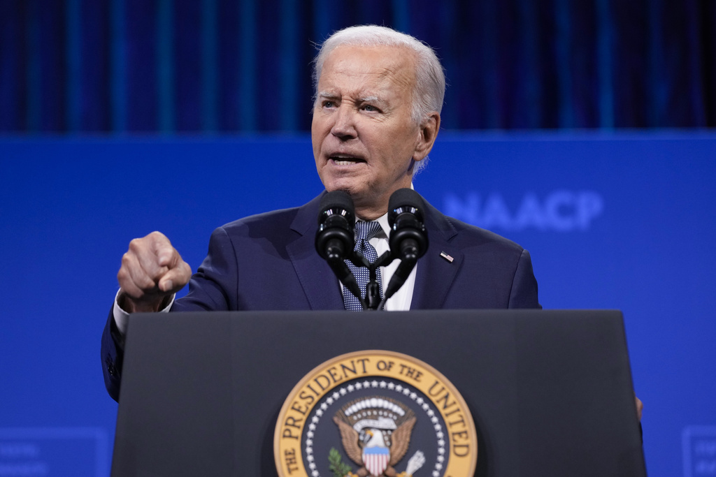 President Joe Bieden speaks at a podium with the presidential seal, against a blue background with "NAACP" partially visible.