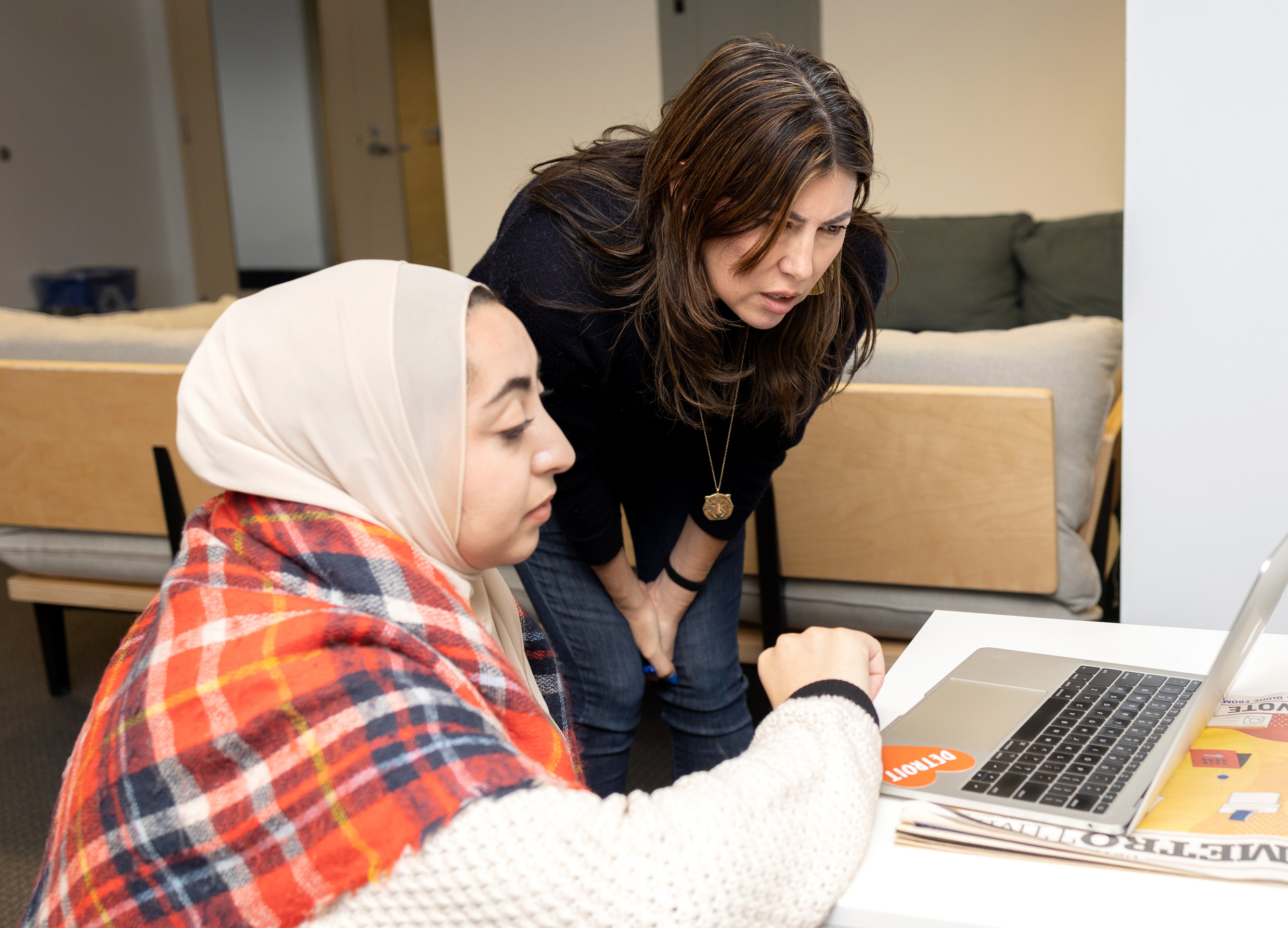 Reporter Miriam Marini and editor Sarah Alvarez look at a laptop in the Outlier offices