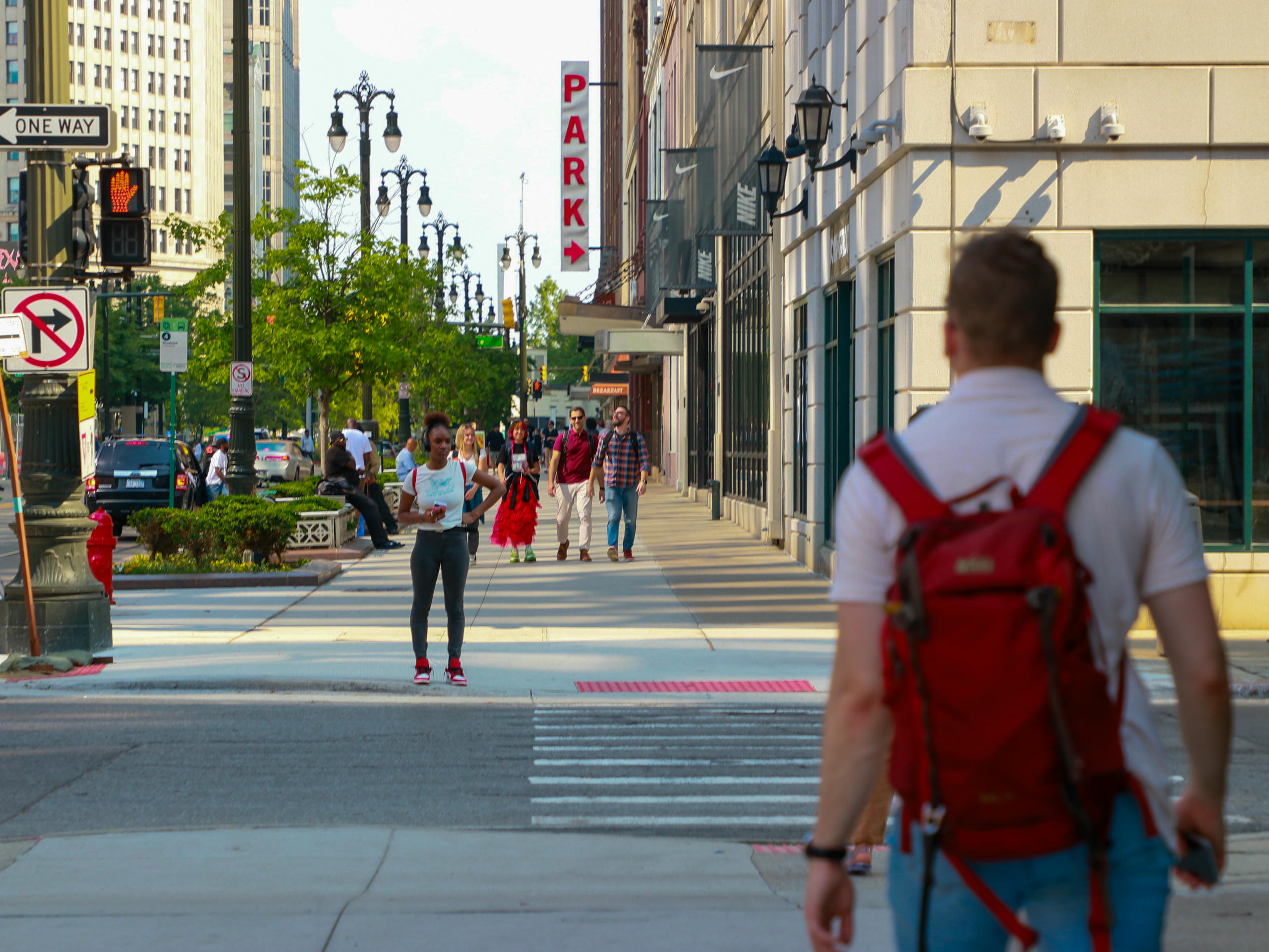 People walk on a sidewalk in a city.