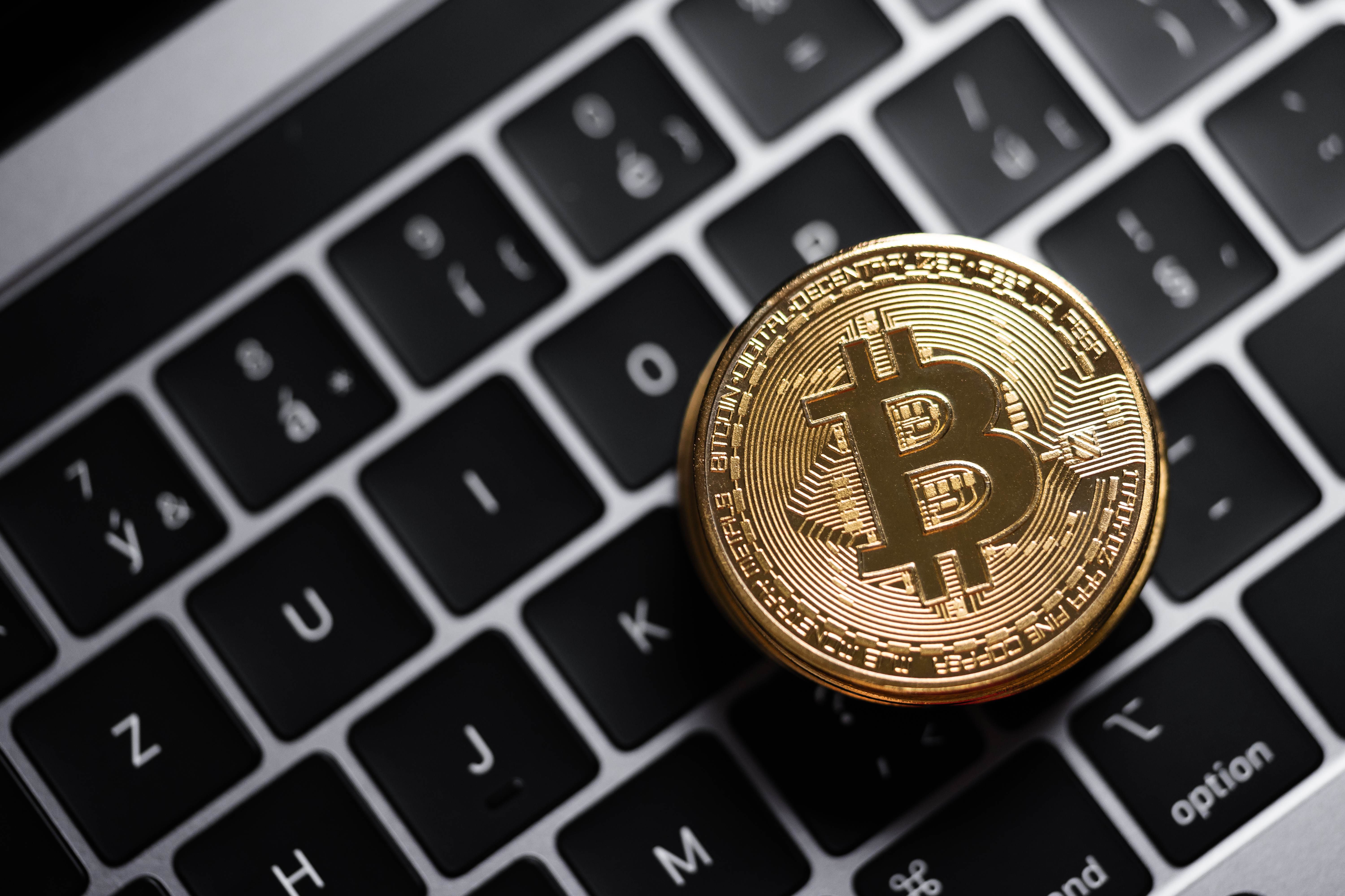 Golden Bitcoin on a MacBook Keyboard Free Photo