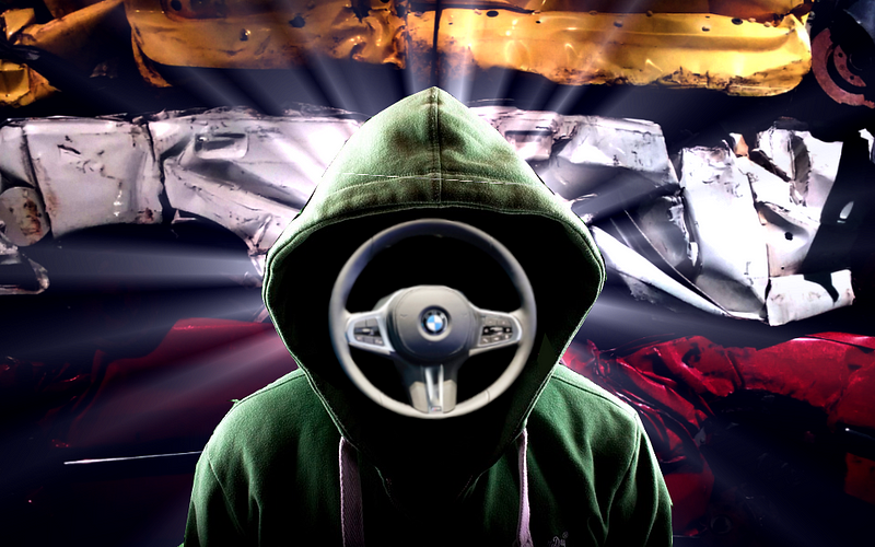 A hackeneyed “hacker in a hoodie” image; in place of a face is a BMW steering wheel. Behind the figure is a three-tier stack of crushed cars.