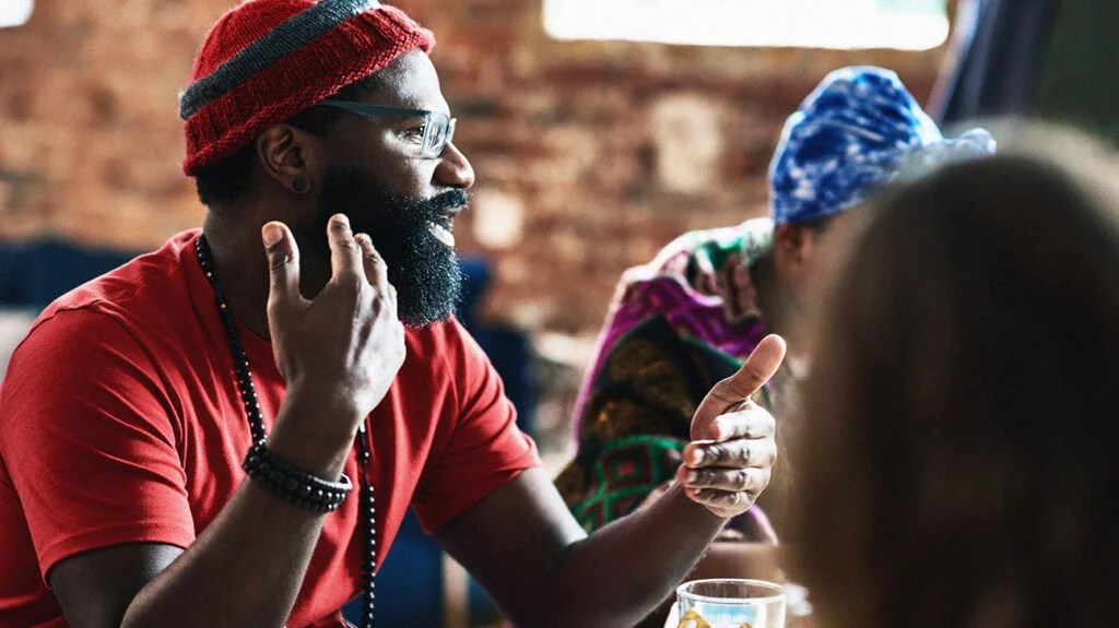 Man with beard and red wooly hat, head and shoulders, explaining and talking about clinical depression