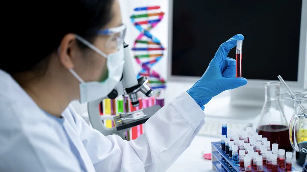 a doctor looking at a blood vial in a hematology lab