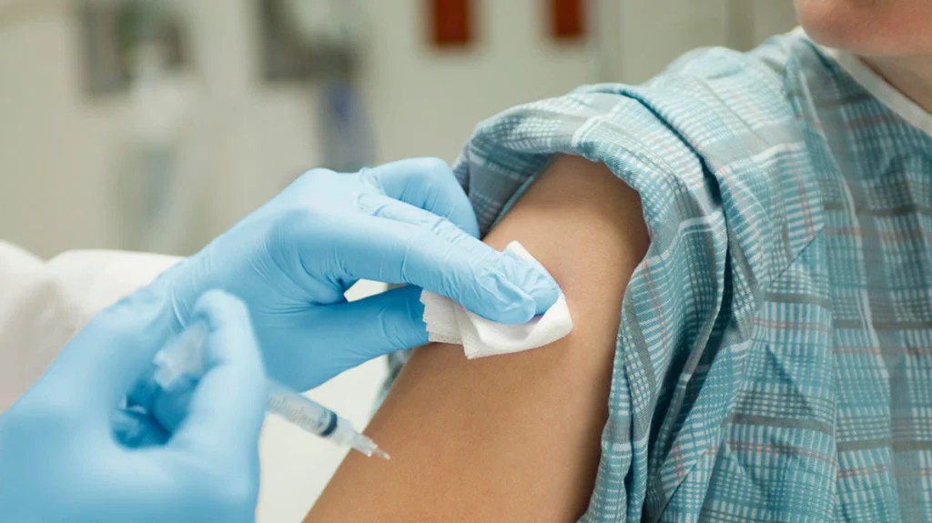 A doctor cleans a patient's arm after administering a birth control shot (Depo-Provera).