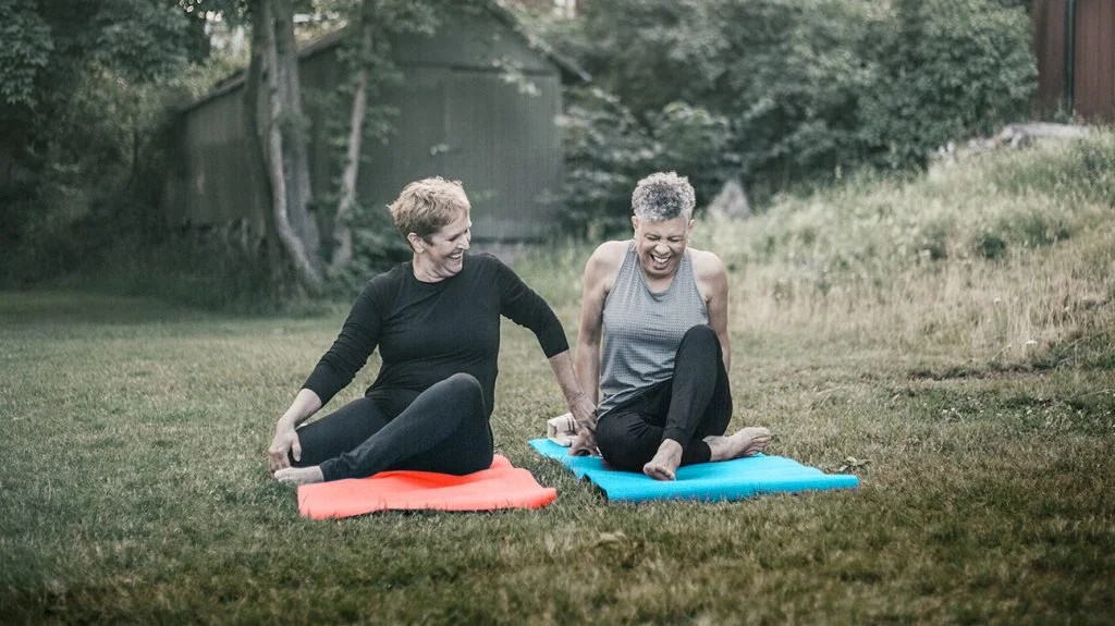 two people doing yoga in the park