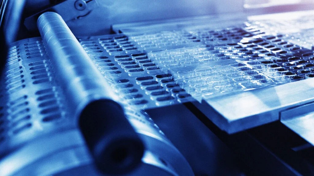 A tray of empty pharmaceuticals and a testing vial. 