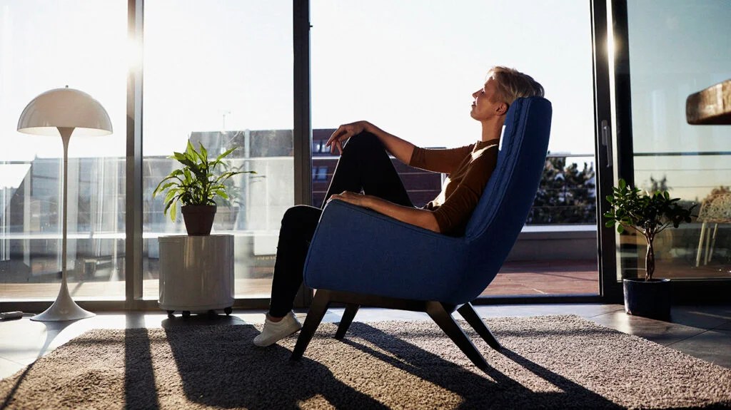 A person is sitting in a chair by a window.