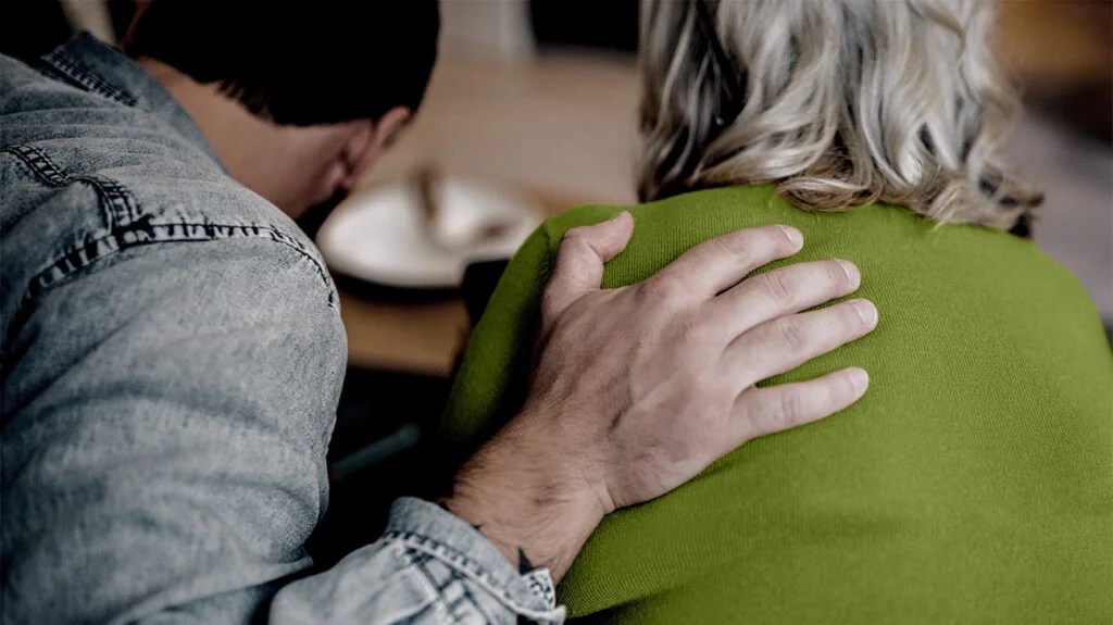 there is a close up of a man with his hand on the shoulder of a woman in a green shirt