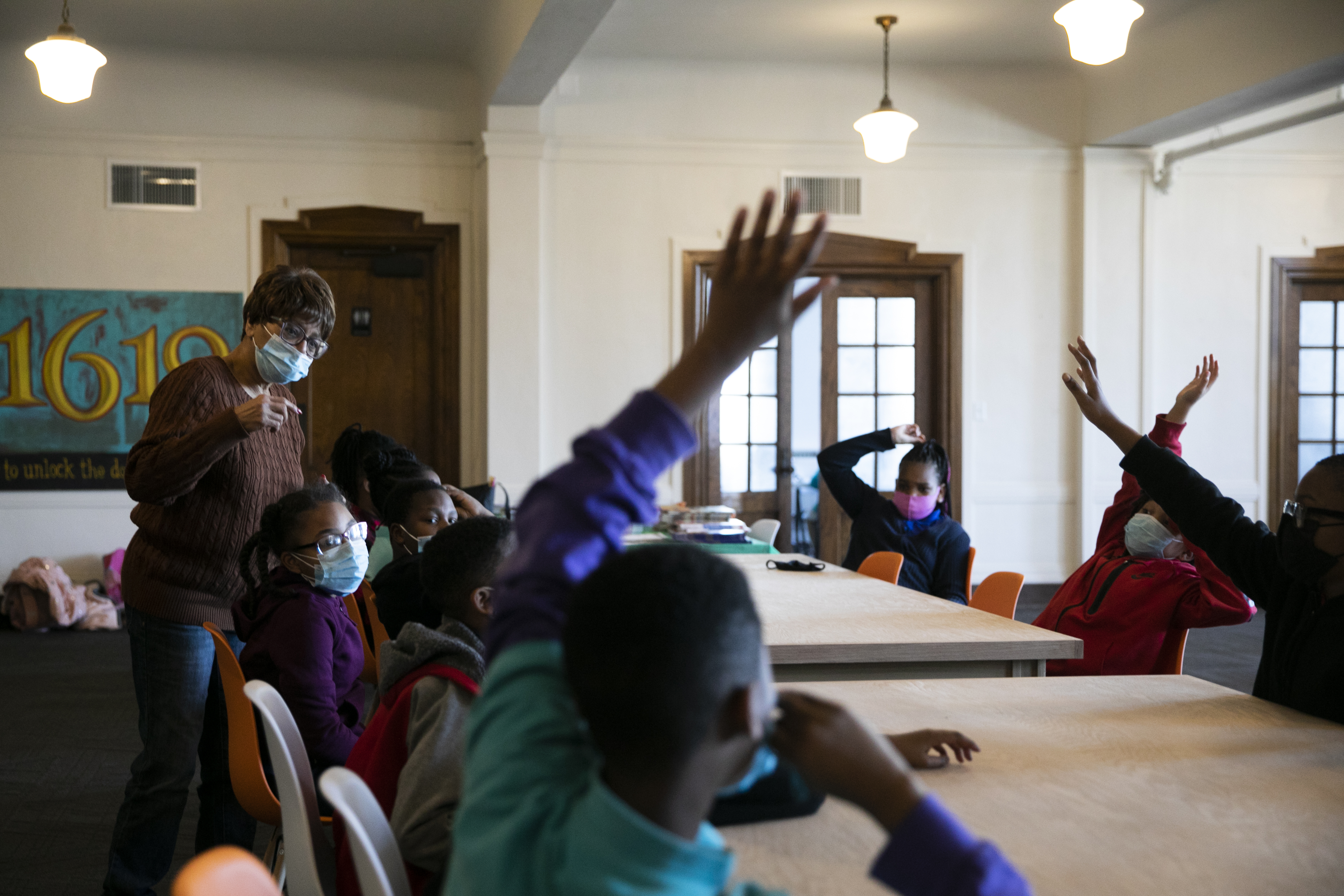 Students raise their hands during a discussion about poetry at the 1619 Freedom School