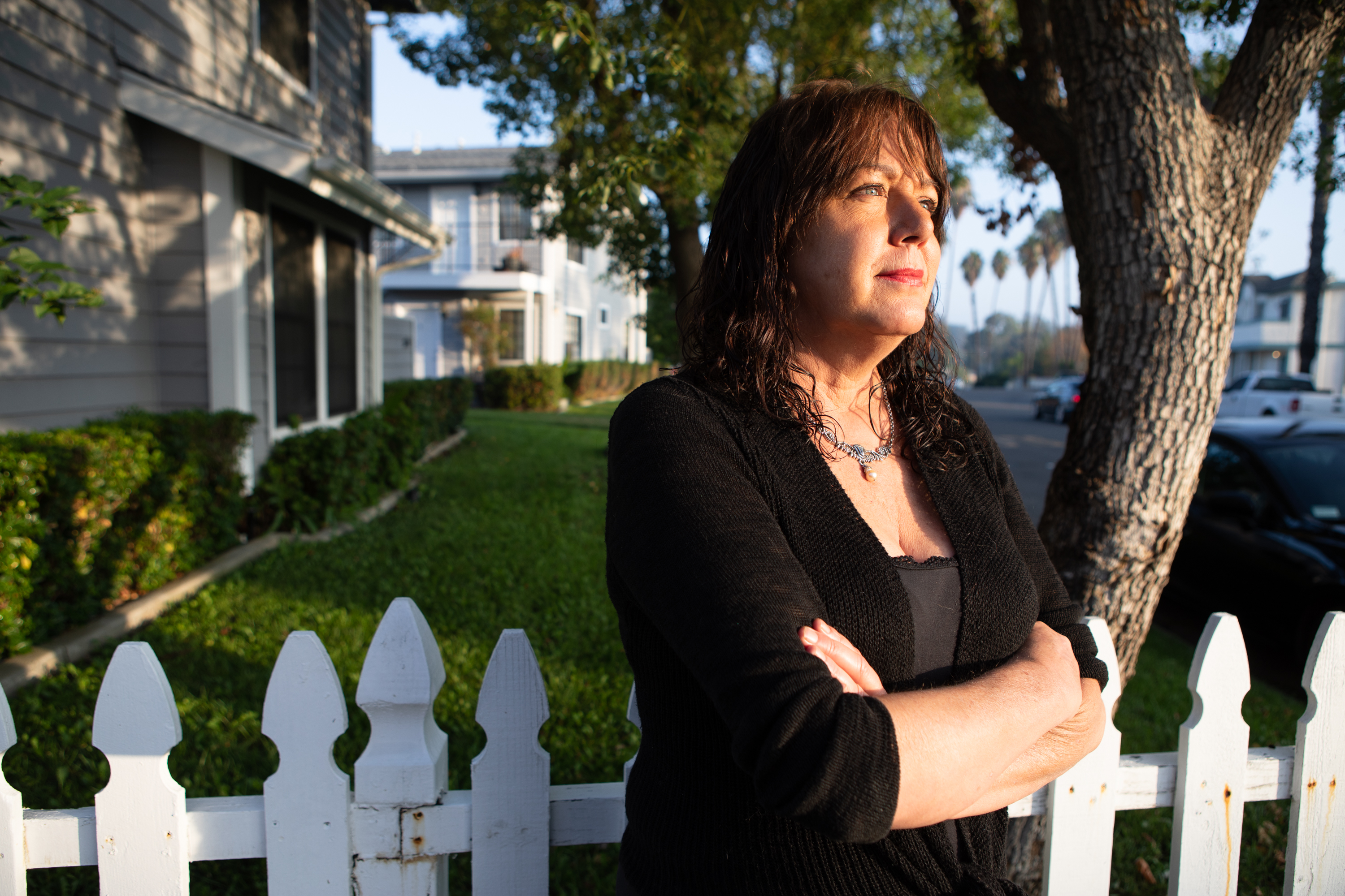 Beth Peterson stands next to the white picket fence in front of her home. She said of her son, "TaeKwonDo is something he does with his grandpa. So wherever we've been, my dad's picked him up three times a week and gotten into TaeKwonDo, so that stayed consistent. And I don't know where he got it from because I was not a good student, he just gets on that Chromebook every single day, whether he's at school or not and he does his work. He's still got straight A pluses. So they made me jump through all kinds of hoops to get him enrolled because we were couch surfing.”