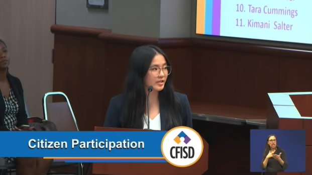 The image is a screenshot from video of the event, showing Victoria Zhang speaking into a microphone. On the screen is an image of the CFISD logo and the text "Citizen Participation"