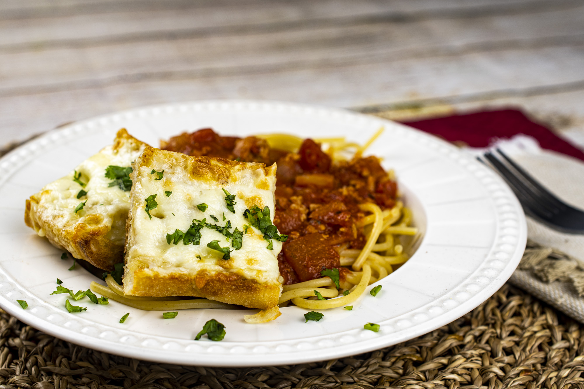 cheesy garlic bread next to spaghetti