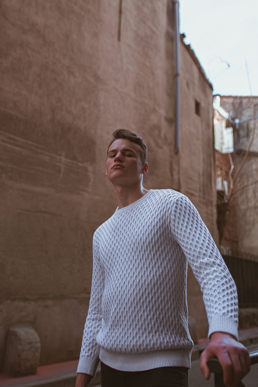 confident young man standing on old town street