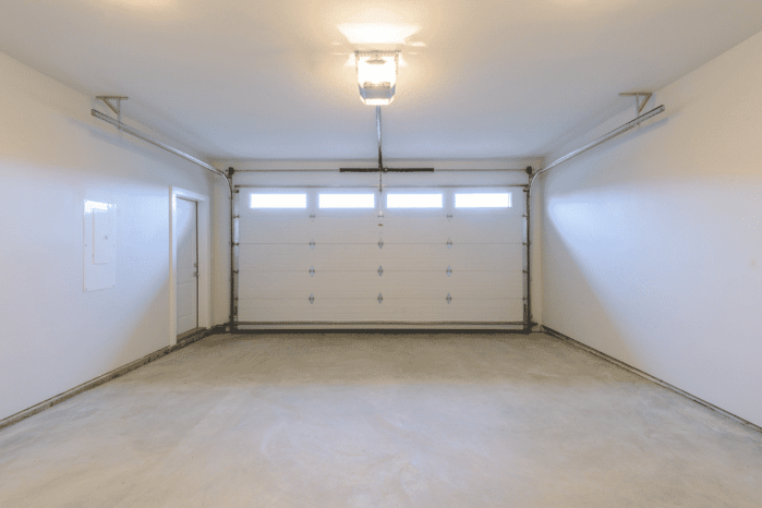 An empty garage with door and windows How to Convert a Garage Into a Bedroom Without Removing the Garage Door