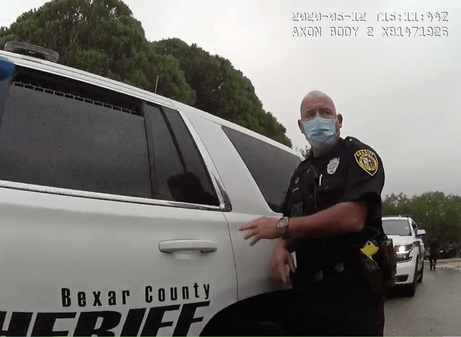 Bexar County Sheriff’s Deputy Patrick Divers approaches the passenger door of a patrol car.