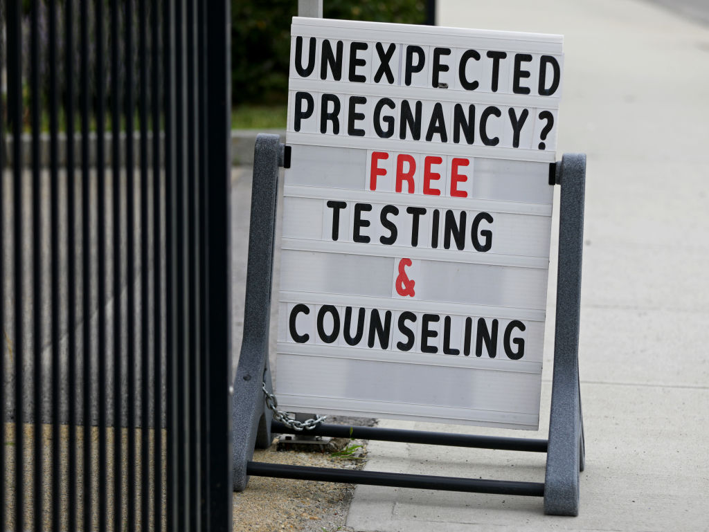 A sign reads: “Unexpected pregnancy? Free testing & counseling.”