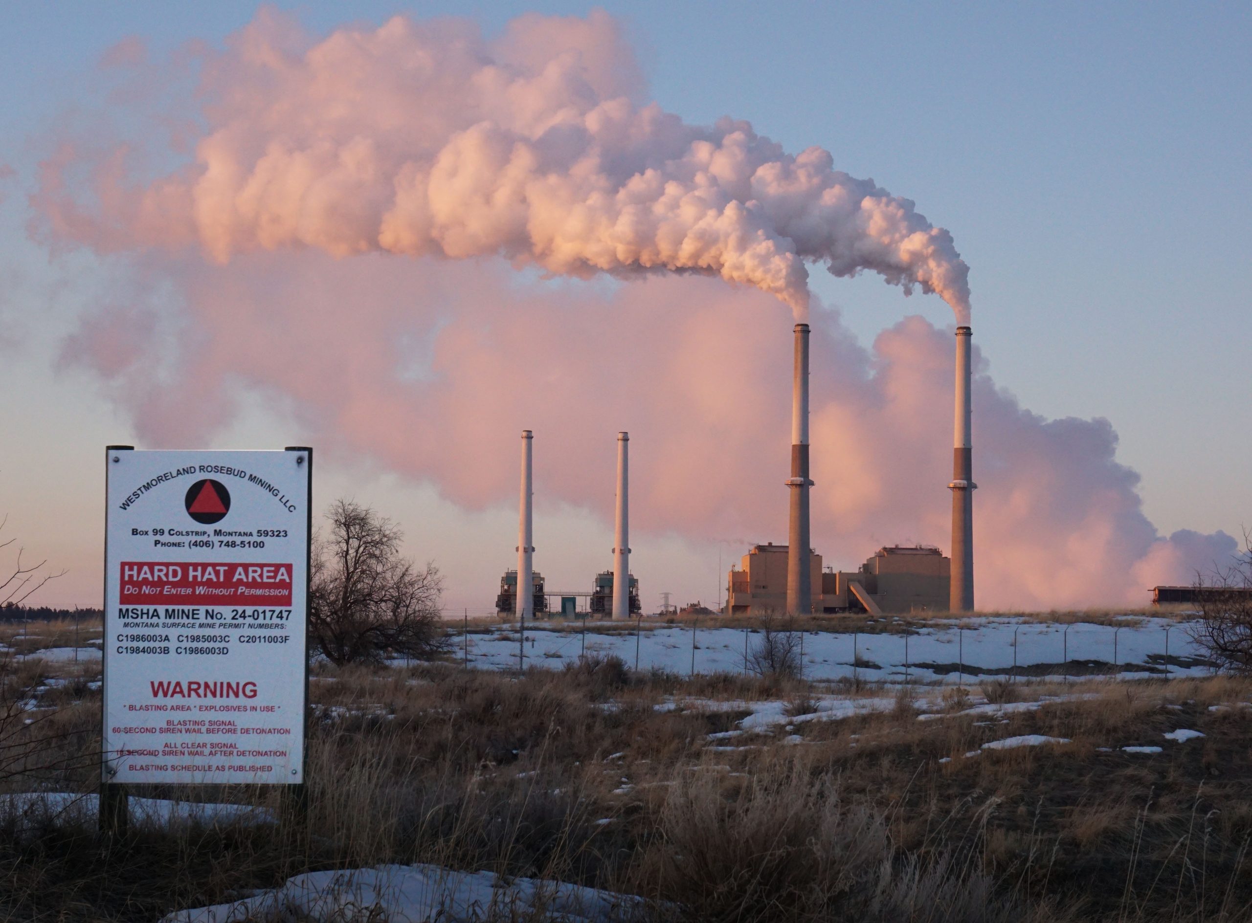 Steam billows out of stacks at a power plant.