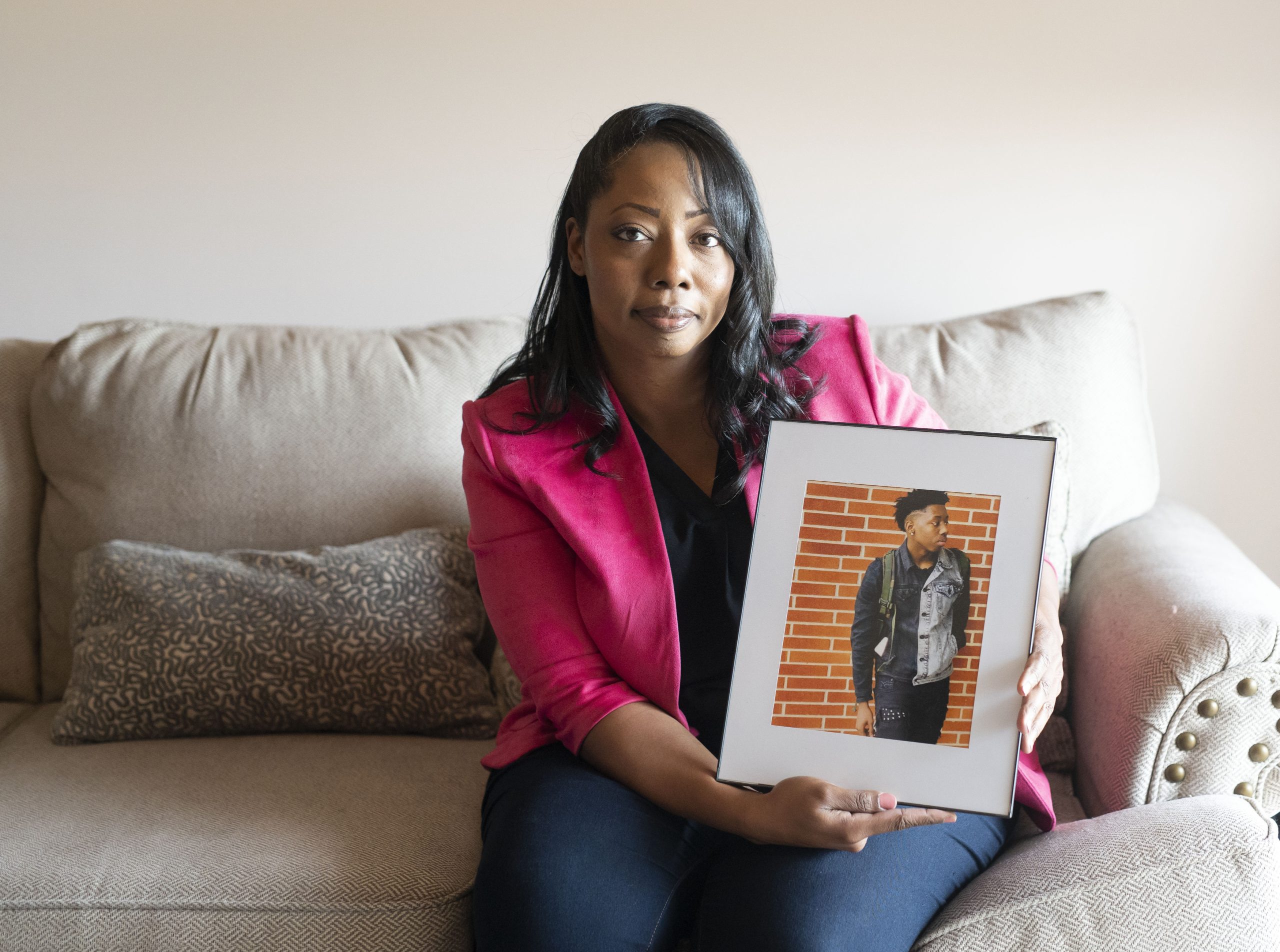 Candace Leslie holds a framed portrait of son Cameron Brown.