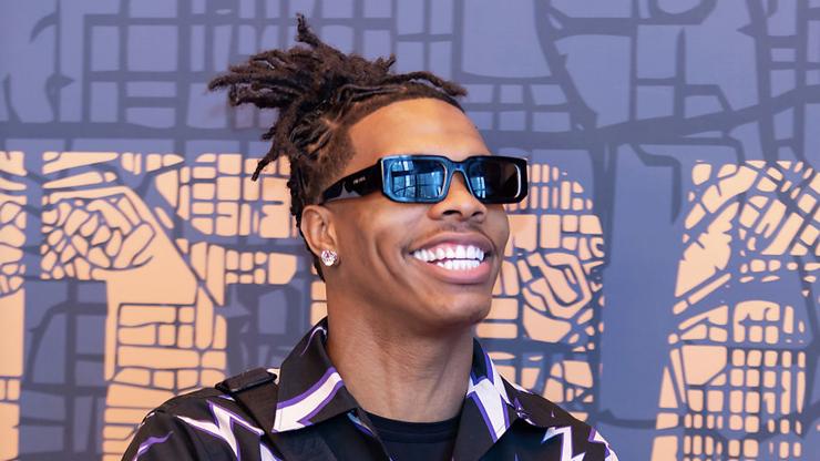 Un fan met de l’argent dans la poche de Lil Baby pendant un spectacle, il le jette par terre