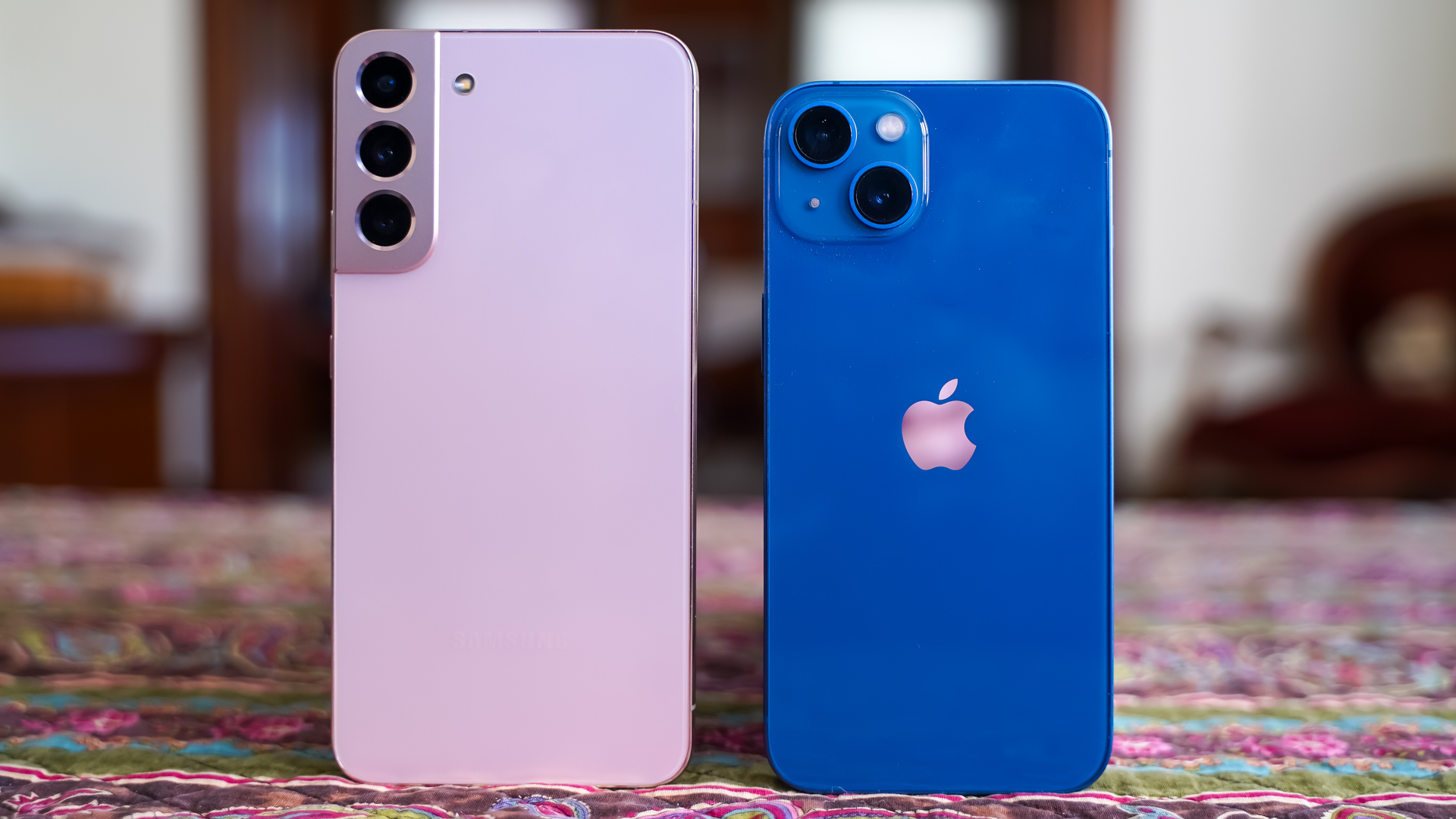 Samsung Galaxy S22 Plus vs Apple iPhone 13 rear on table