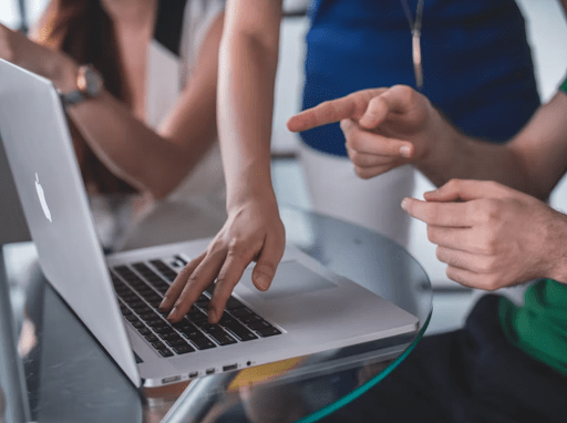 Image of people working around a laptop