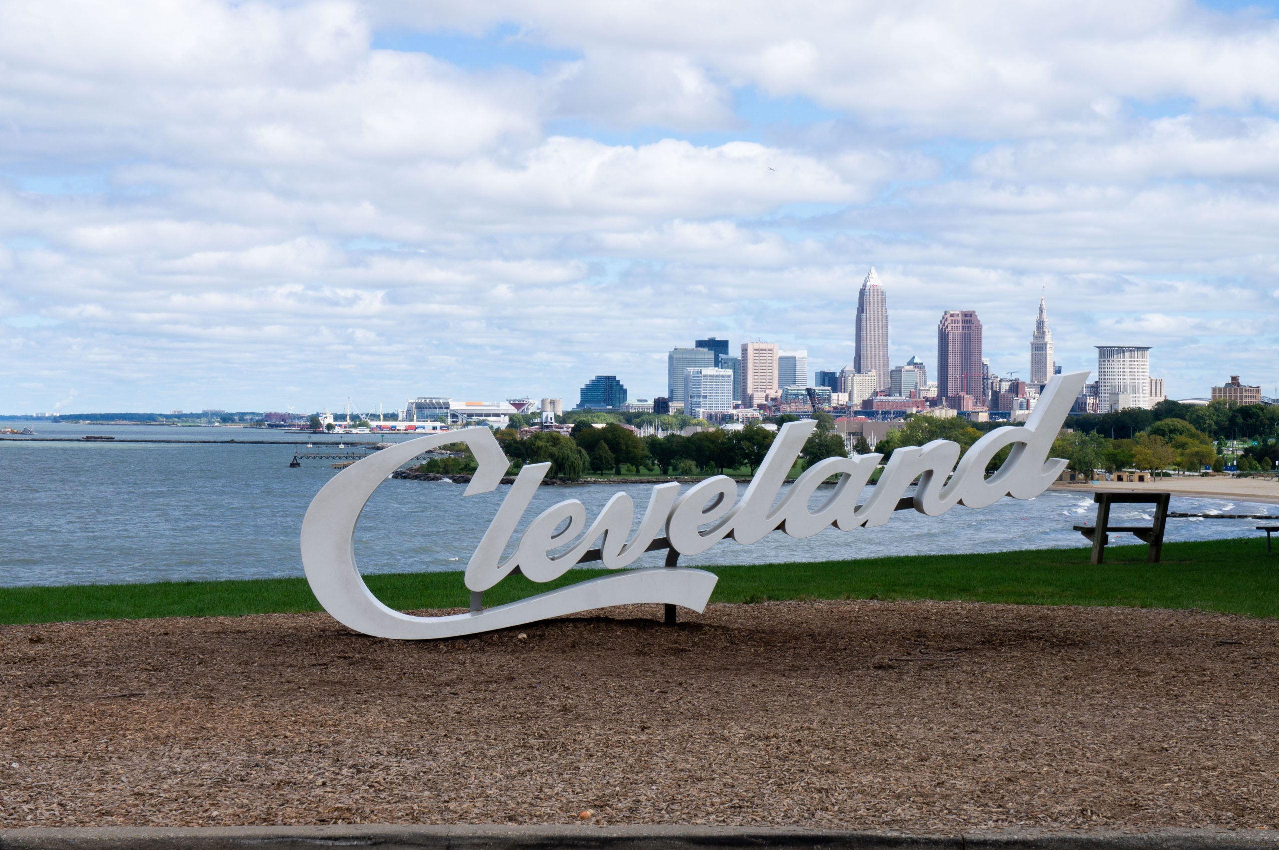 Script Cleveland sign with skyline in the background.