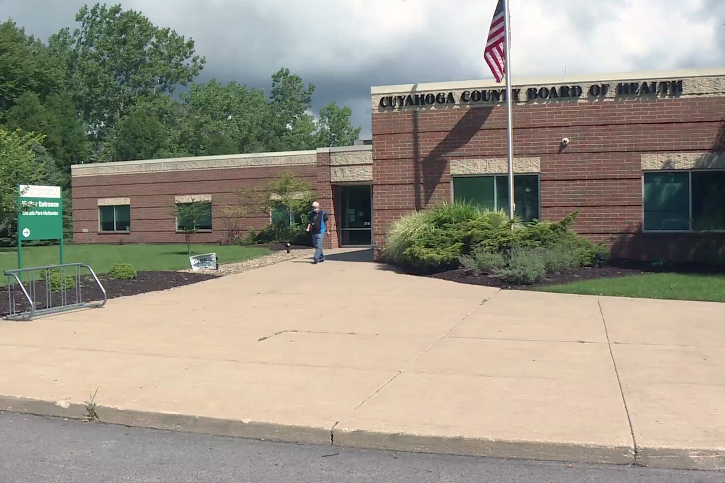 Exterior of red brick Cuyahoga County Board of Health Building, with U.S. flag out front.