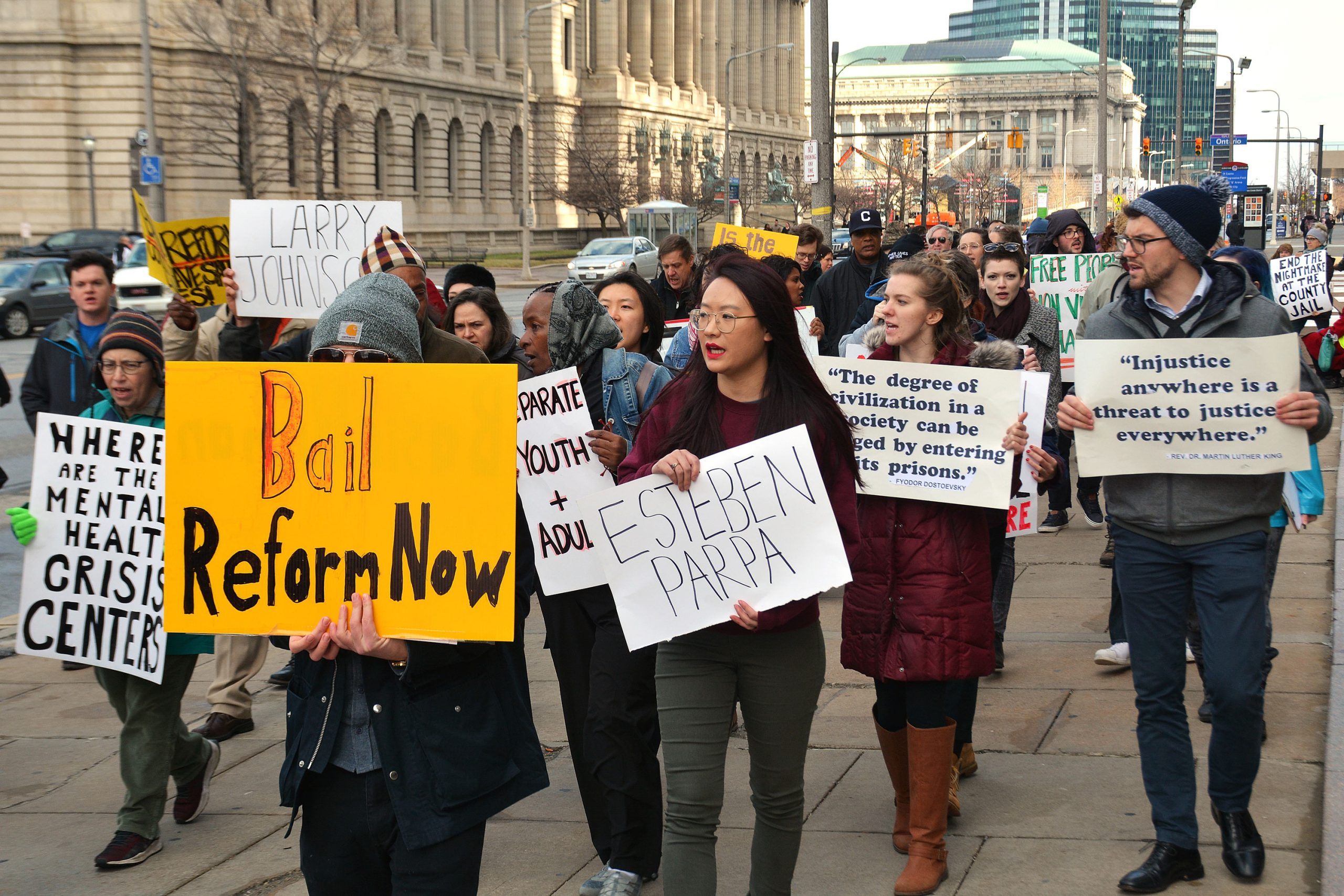 A group of more than 30 protestors walk through Cleveland’s downtown, holding posters advocating for bail reform and better conditions at the county jail