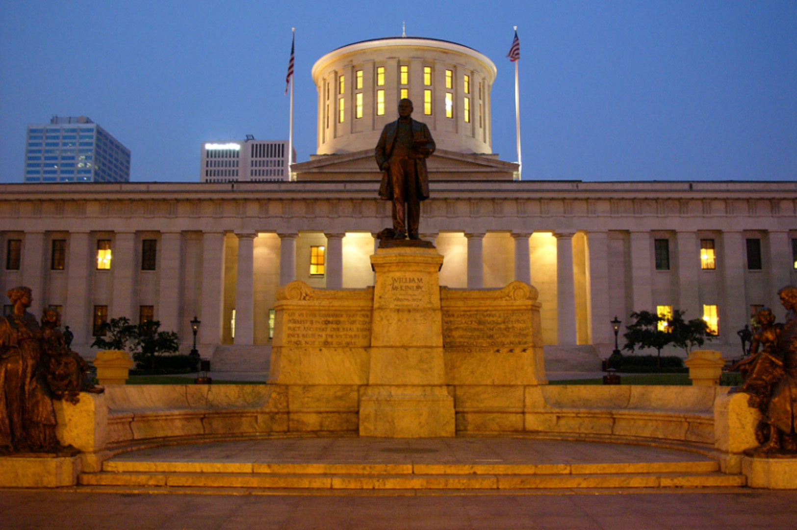 The Ohio Statehouse at night with lights on in the rotunda.