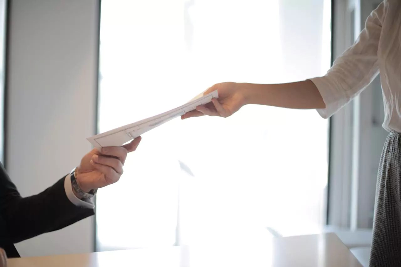 a woman handing her resume to the interviewer