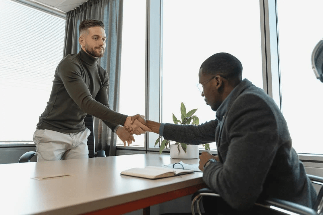 Two men shaking hands after networking for a job