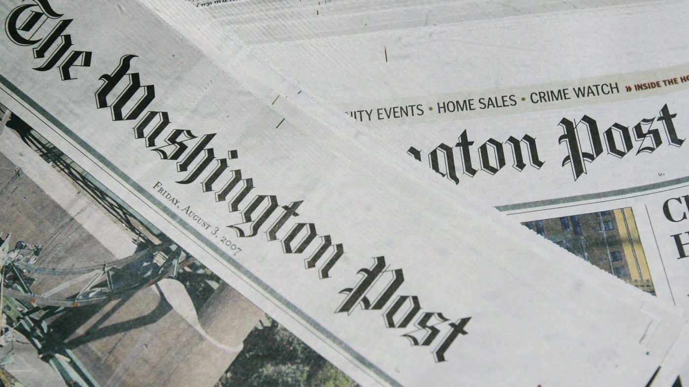 Sections of The Washington Post newspaper are displayed in a pile.