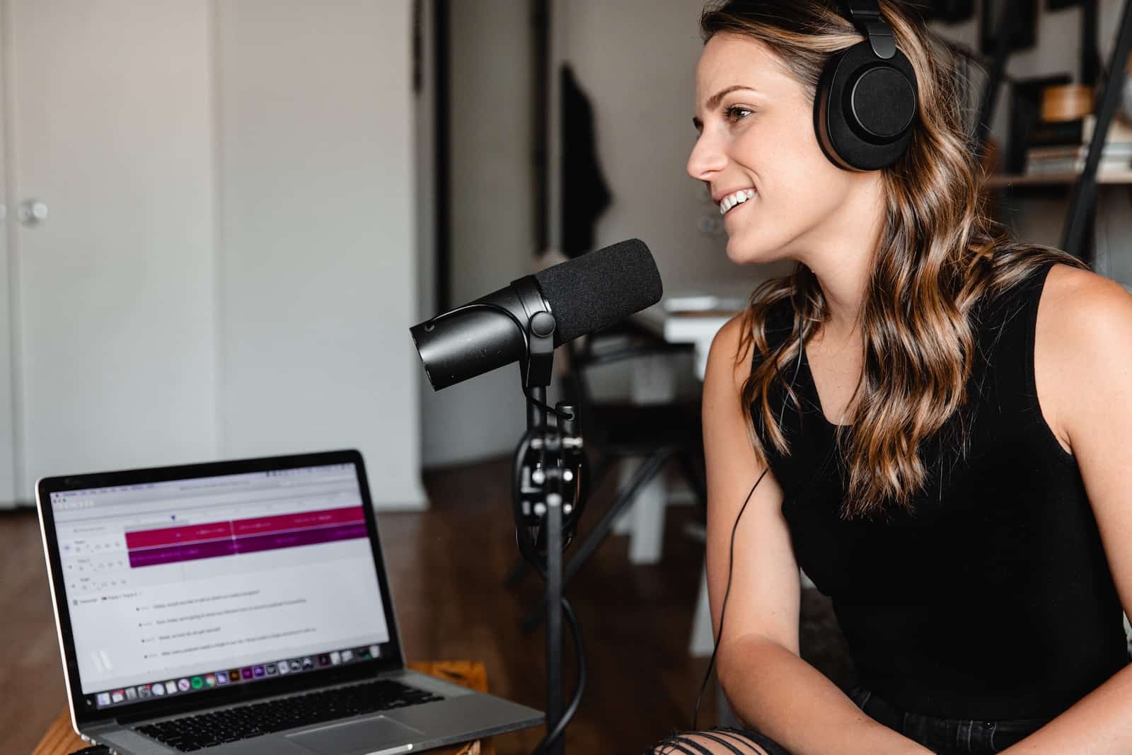 woman in black tank top sitting on chair in front of microphone-language learning podcasts