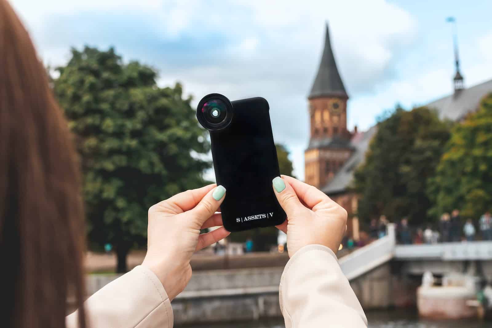 person holding black camera taking photo of brown concrete building during daytime-smartphone photography