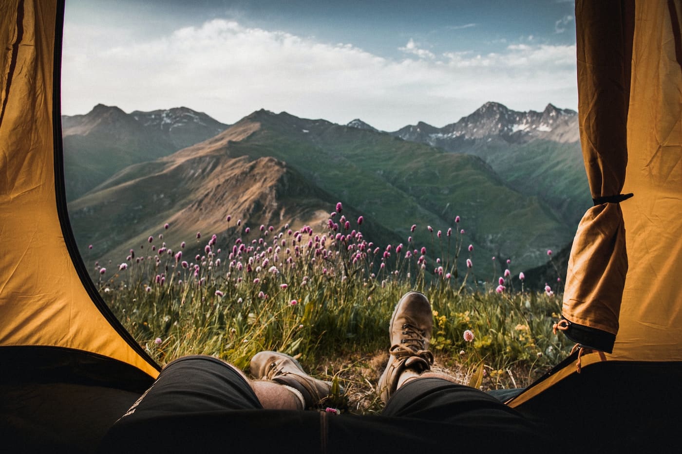 person lying inside tent and overlooking mountain-camping skills