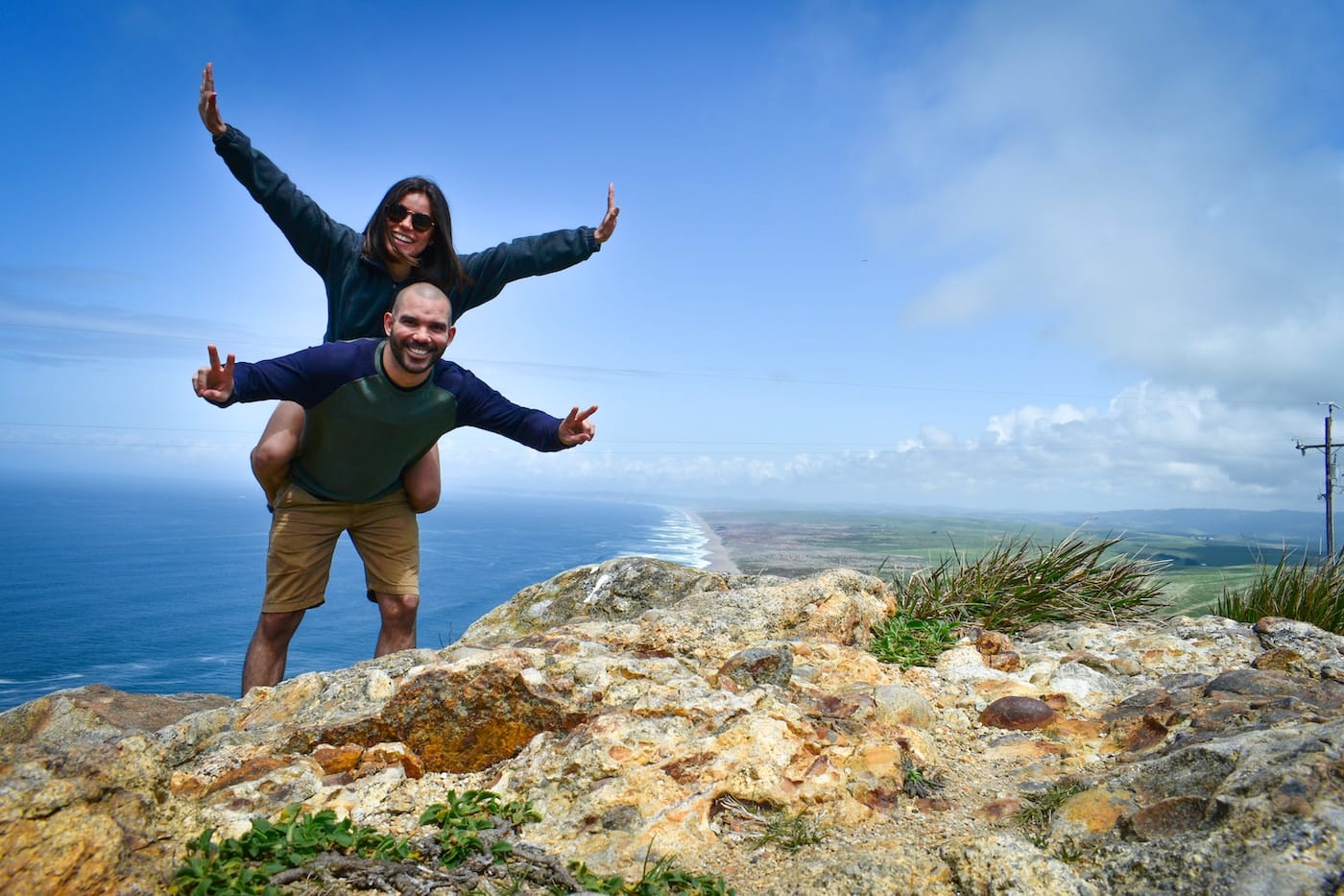 man in blue shirt and brown shorts standing on rock formation during daytime-Nature Honeymoon