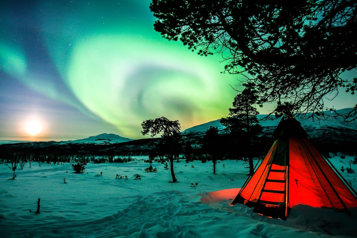 orange tent on snow covered ground during night time-Northern Lights