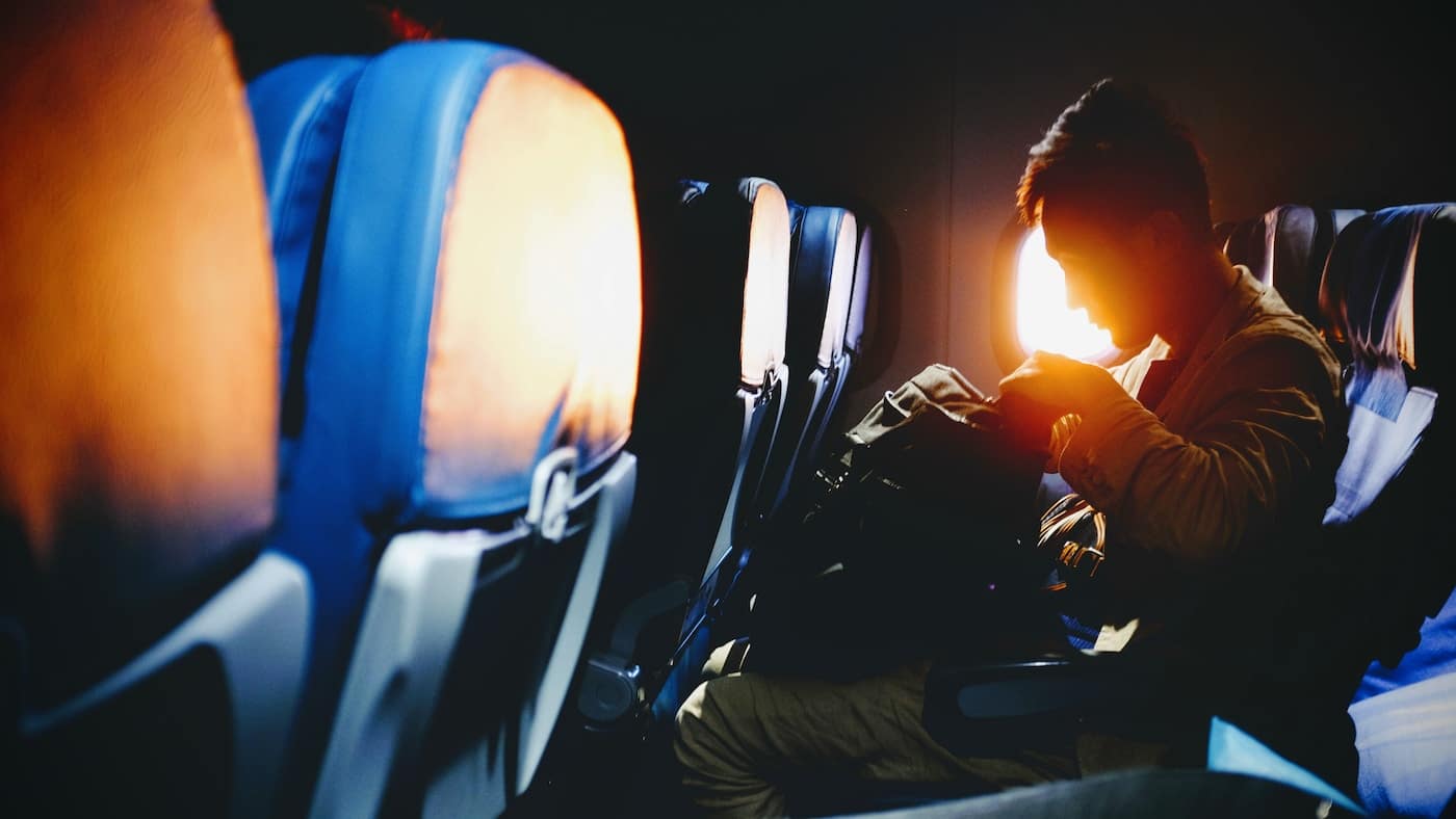 man looking on his sitting on plane seat-Fun Things to Do on a Long Flight