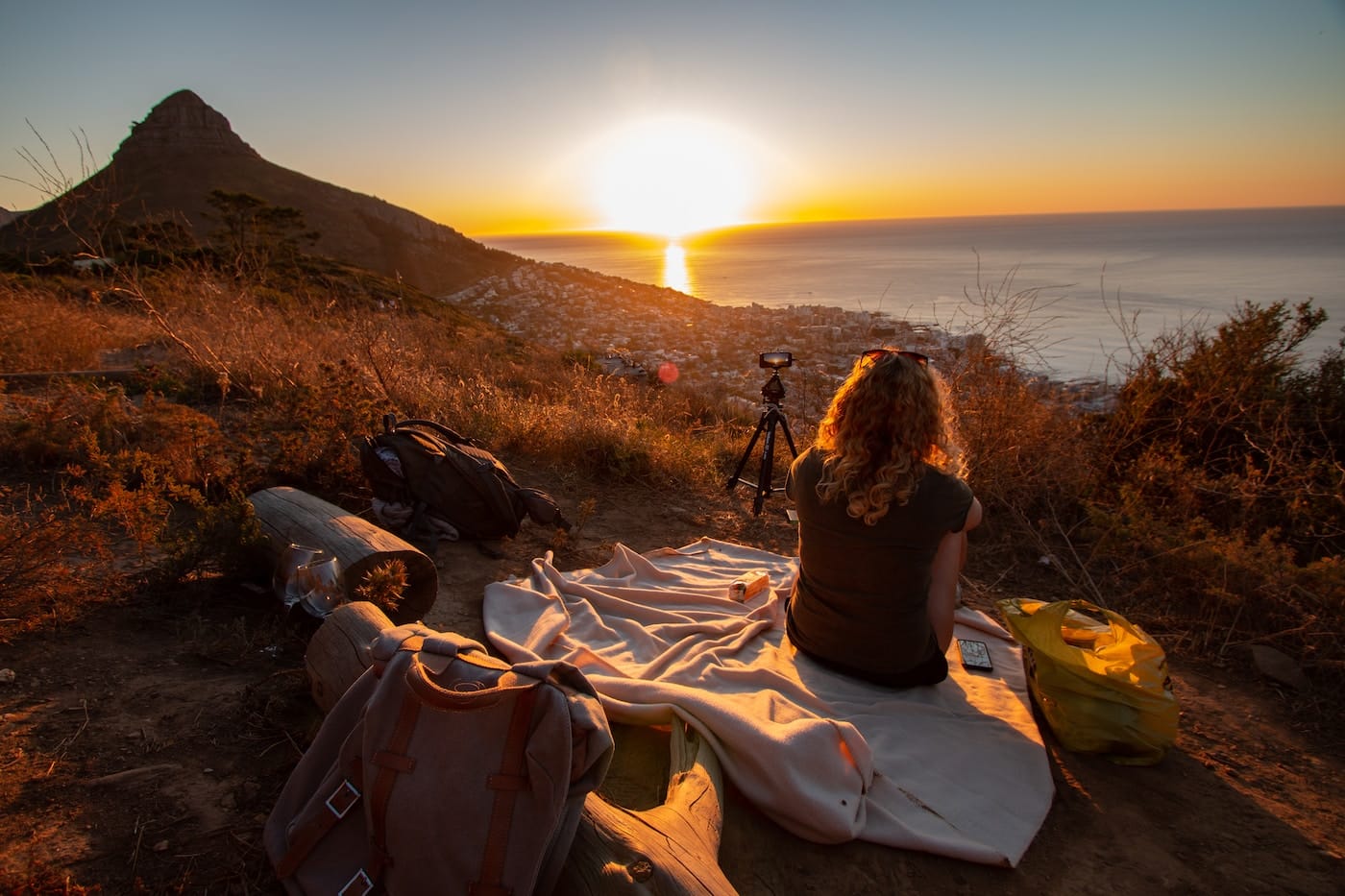 woman sitting on blanket near sea and mountain during dawn-Cape Town Solo Travel