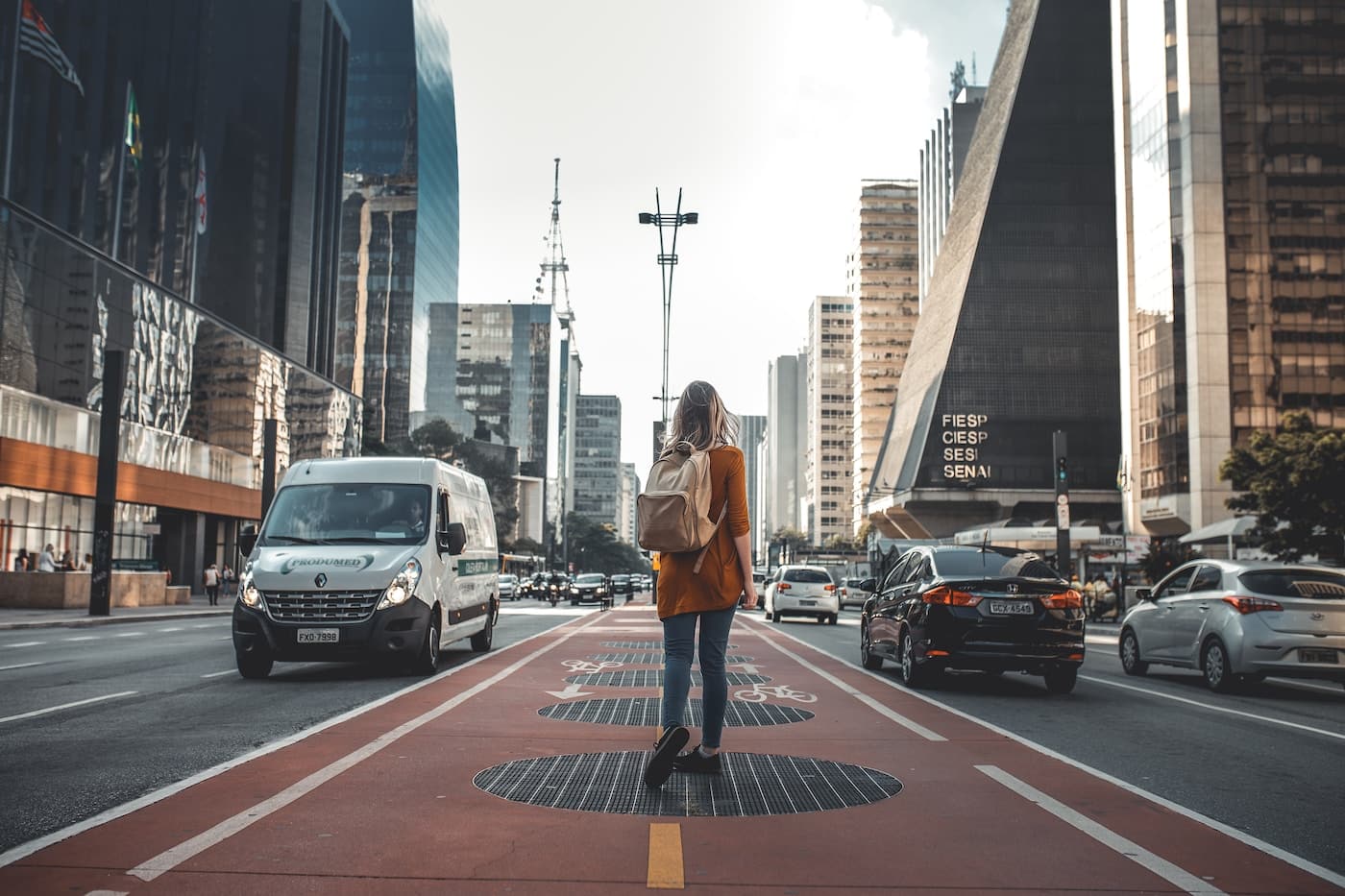 photography of woman walking in between road with vehicles-What Solo Travel Teaches You