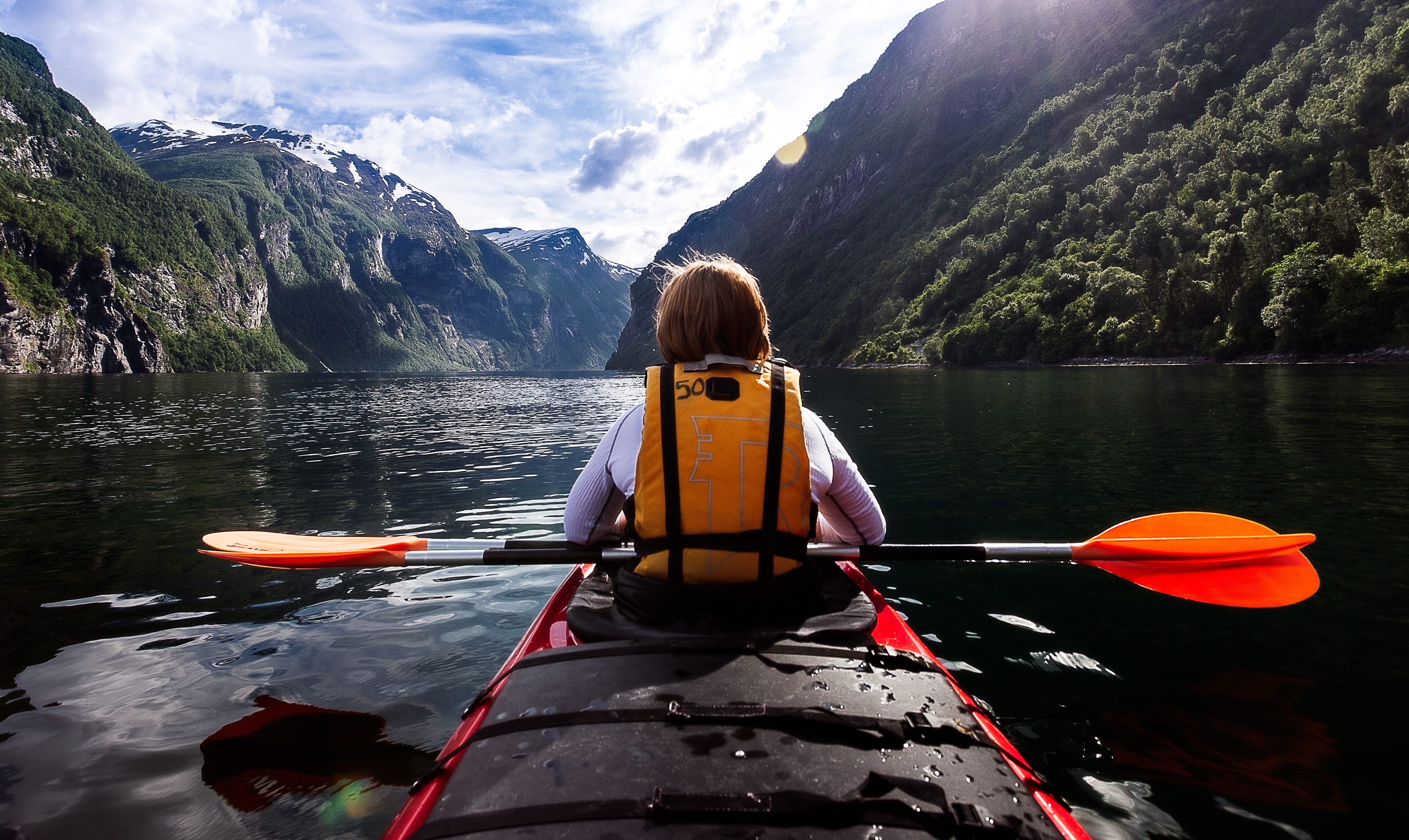 a teen on a kayak in the mountains