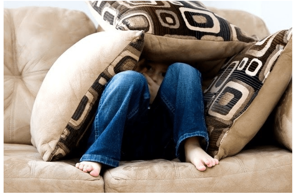 A teen hiding the cushions of a couch