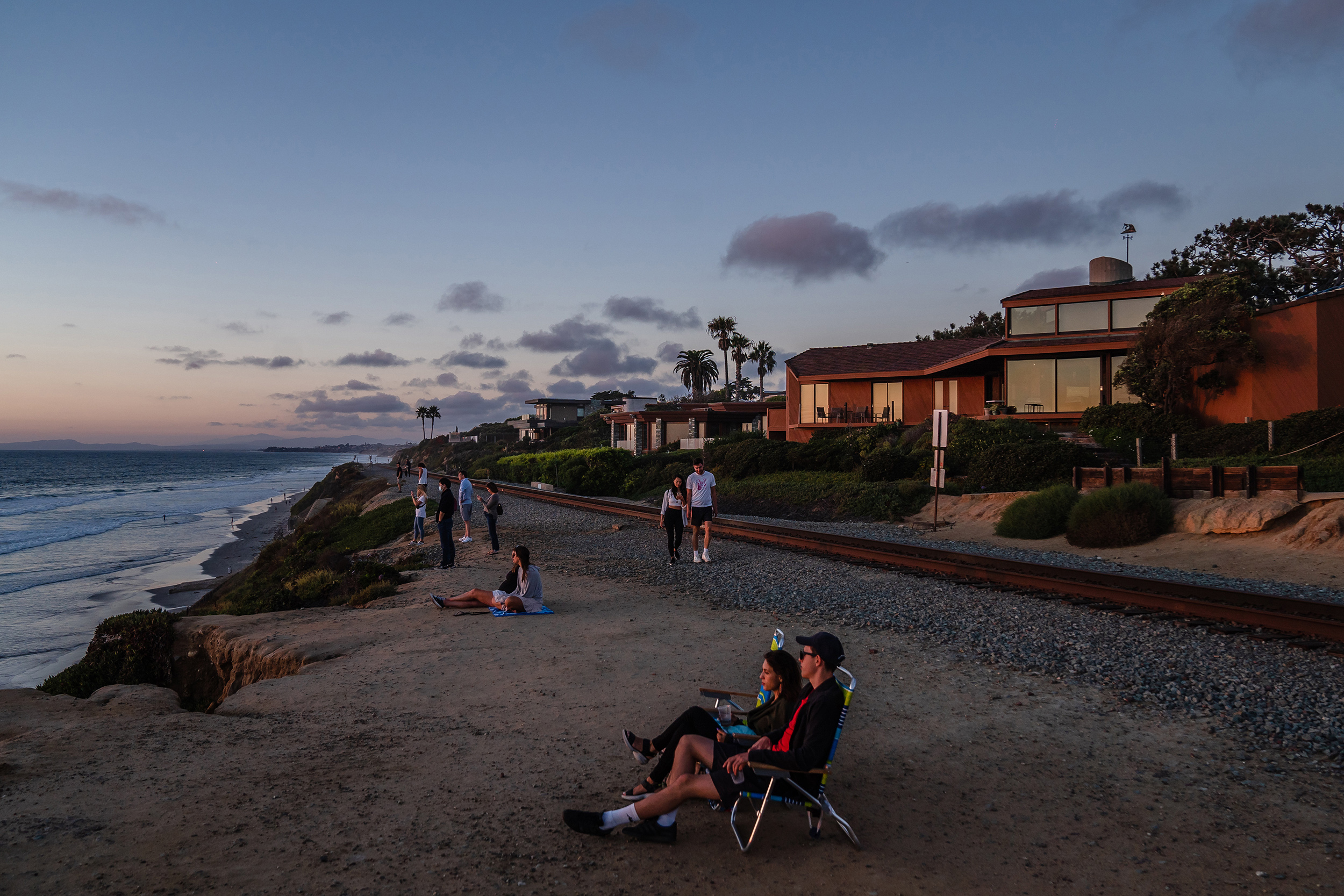 People watch the sunset near the train tracks in Del Mar on Sept.19, 2022.