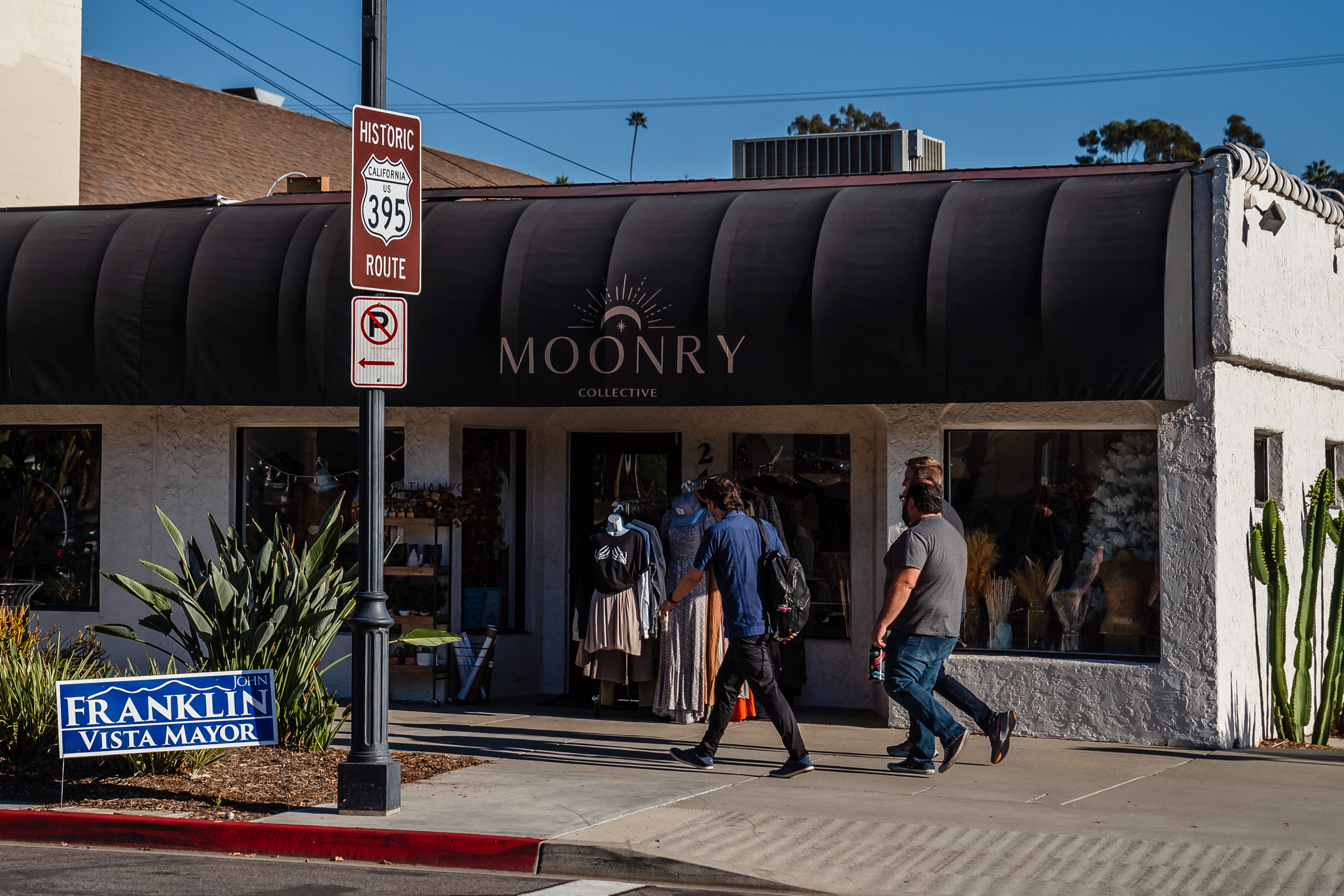 Men walk on Main Street in Vista on Oct. 18, 2022.